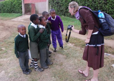 Daniels student show a group children her camera