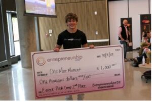 Denver Persinger stands with his $1,000 second place check from the EWeek Pitch Competition.