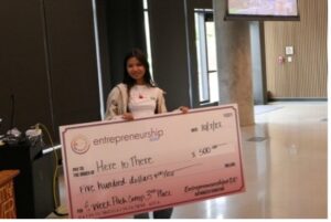 Kasey Shen stands with her $500 third place check from the EWeek Pitch Competition.