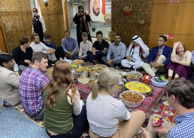 Students seated on the floor enjoying a meal