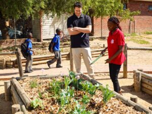 A PMBA student and Love to Give member work together on a garden.