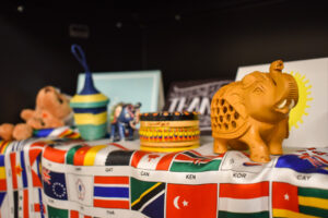 An elephant and other trinkets sit atop a banner of international flags